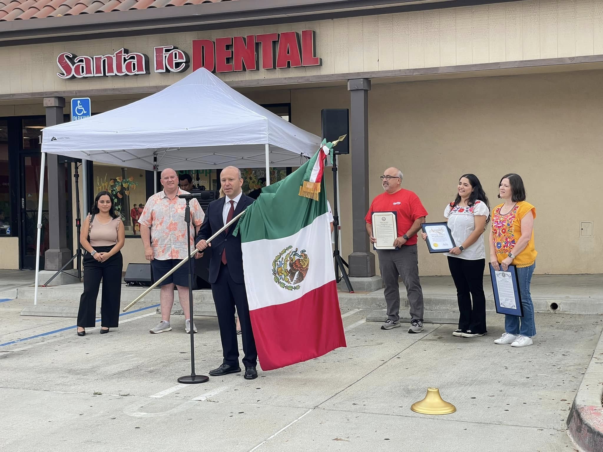 Fiestas Patrias participants with the Mexican flag outside Santa Fe Dental Group